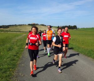 RUNNING Company Toskana Laufferien: glückliche Läufer und grüne Hügel