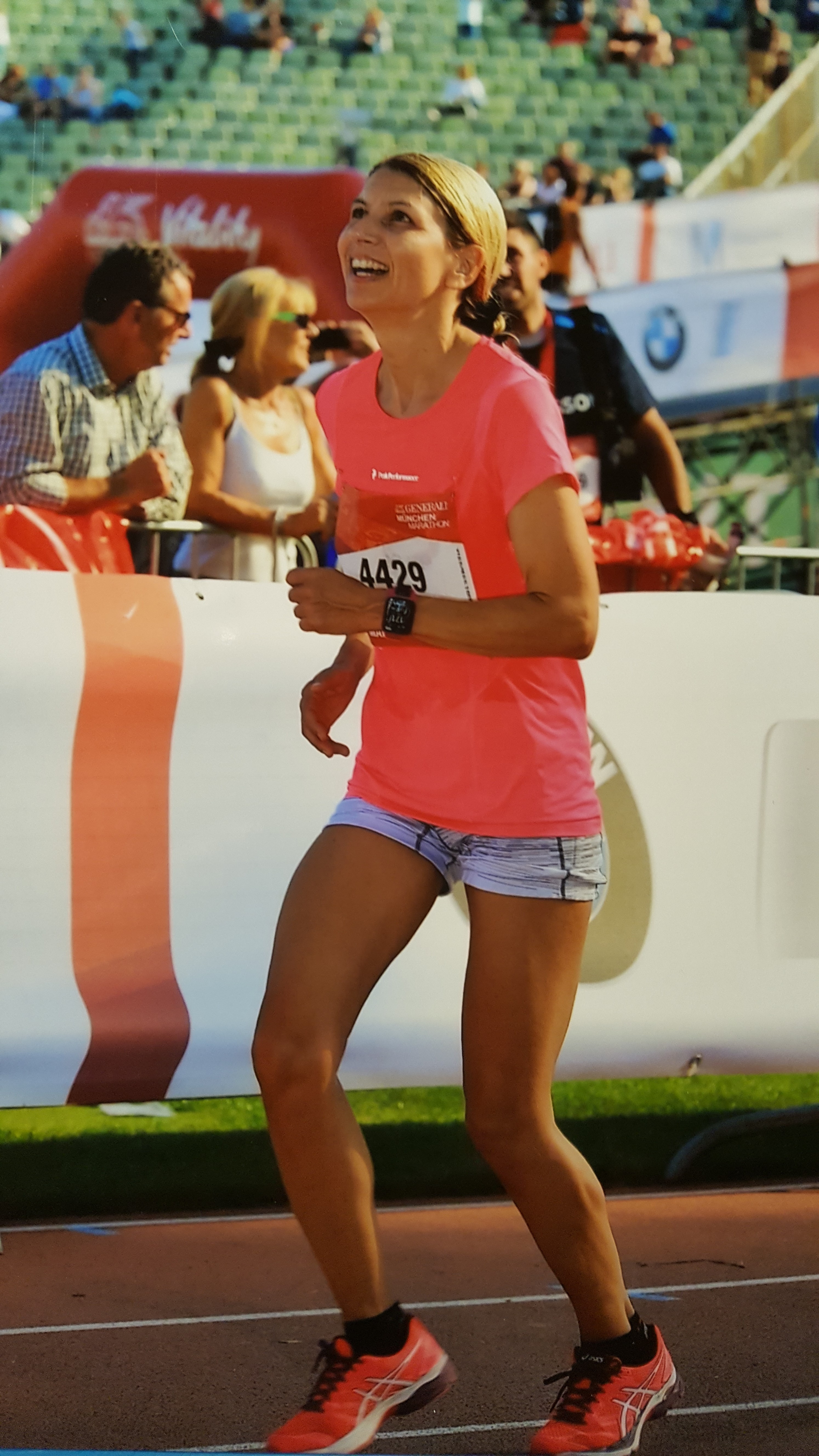 Glückliche Läuferin im Ziel beim Generali München Marathon